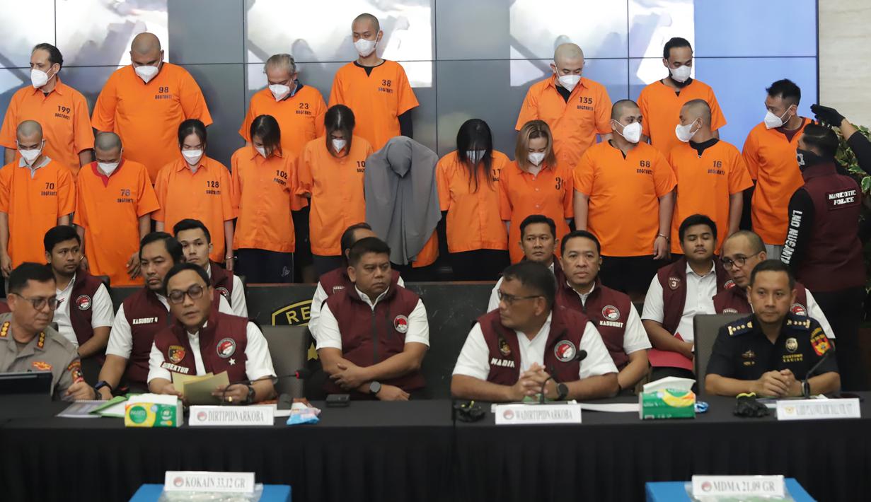 Sebanyak 17 tersangka pengedar narkoba digelandang aparat kepolisian saat konferensi pers di gedung Bareskrim Mabes Polri, Jakarta, Senin (22/12/2025). Bareskrim Polri mengungkap kasus peredaran narkoba yang rencananya diselundupkan dalam gelaran acara Djakarta Warehouse Project (DWP) 2025 di Bali pada 12–14 Desember 2025 lalu. (merdeka.com/Arie Basuki)