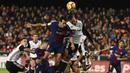 Gelandang Barcelona, Sergio Busquets, duel udara dengan bek Valencia, Ruben Vezo, pada laga La Liga Spanyol di Stadion Mestalla, Valencia, Minggu (26/11/2017). Kedua klub bermain imbang 1-1. (AFP/Jose Jordan)