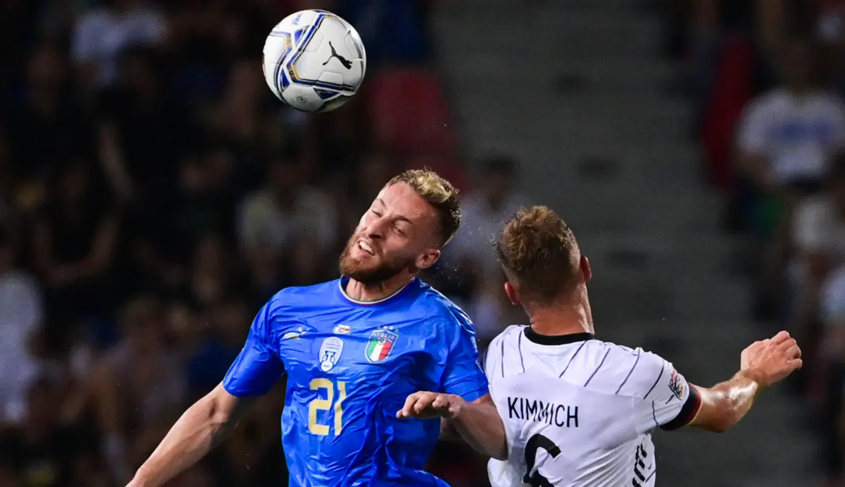 Gelandang timnas Italia Davide Frattesi (kiri) dan gelandang Jerman Joshua Kimmich melakukan sundulan saat bersaing pada matchday pertama UEFA Nations League A Grup 3 di Renato Dall'Ara, Minggu (6/5/2022) dini hari WIB. Jerman bermain imbang melawan Italia dengan skor 1-1. (MIGUEL MEDINA / AFP)