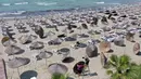 Foto udara pada 1 Juni 2020 menunjukkan para pekerja memasang payung jerami di sebuah pantai di Qerret, dekat kota Kavaja, Albania. Rencananya pada 6 Juni mendatang, semua pantai umum akan dibuka untuk wisatawan setelah Albania menerapkan langkah-langkah pelonggaran pencegahan virus corona. (SHKULLA
