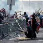 Polisi menyingkirkan barikade yang dibuat demonstran saat unjuk rasa atas kematian George Floyd oleh polisi di luar Third Police Precinct, Minneapolis, Minnesota, Amerika Serikat, Rabu (27/5/2020). Kematian George Floyd memicu kerusuhan di Minneapolis. (Kerem Yucel/AFP)