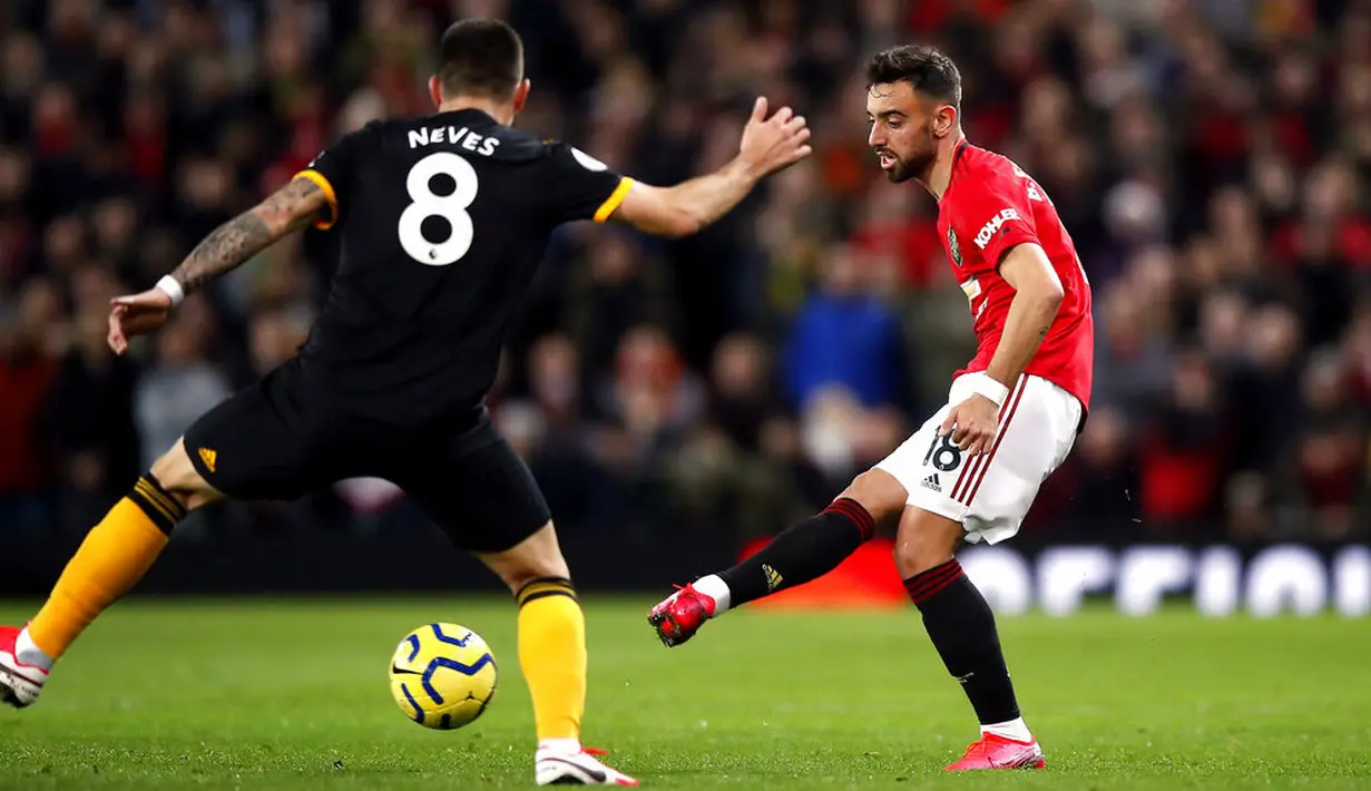 Gelandang Manchester United, Bruno Fernandes, menendang bola saat melawan Wolverhampton Wanderers, Matt Doherty, pada laga Premier League di Stadion Old Trafford, Sabtu (1/2/2020). Kedua tim bermain imbang tanpa gol. (AP/Martin Rickett)