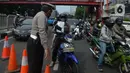 Pengendara motor menunjukkan surat saat penyekatan di ruas jalan Mampang Prapatan, Jakarta, Kamis (15/7/2021). Mampang menjadi salah satu jalan yang masuk dalam penyekatan baru pada Pemberlakuan Pembatasan Kegiatan Masyarakat (PPKM) darurat di Ibu Kota. (merdeka.com/Imam Buhori)