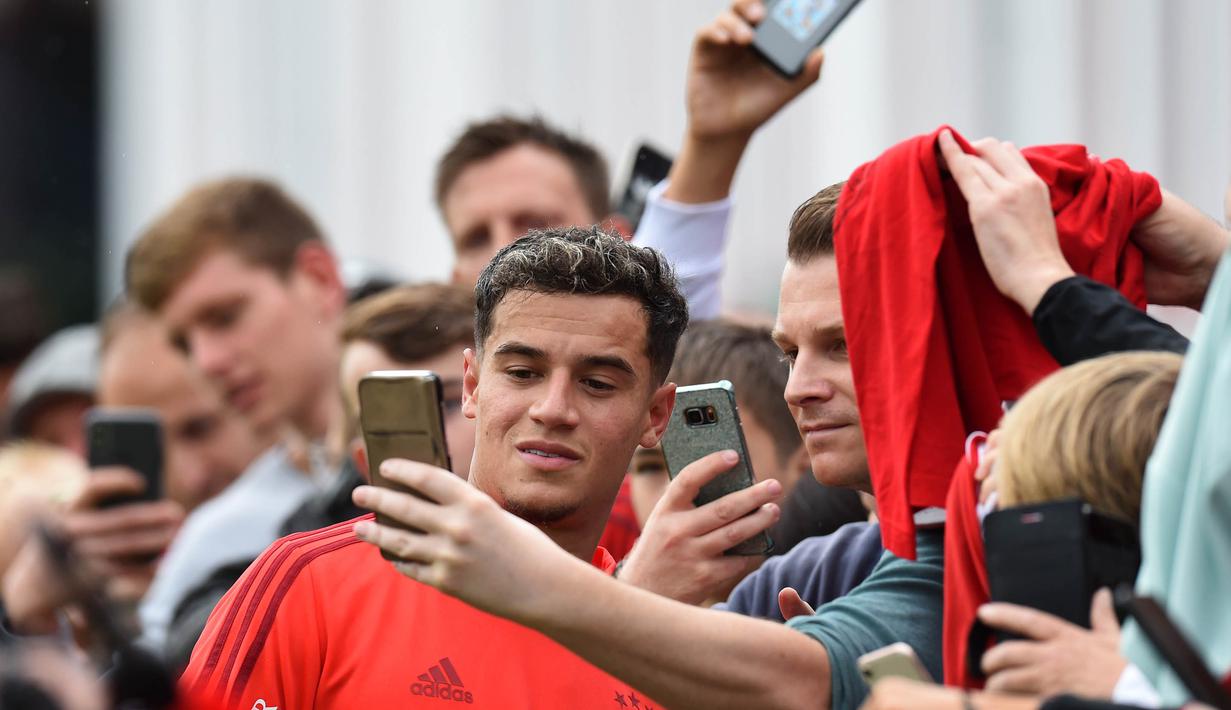 Pemain Bayern Munchen, Philippe Coutinho, menyapa suporter saat latihan perdananya di Munchen, Selasa (20/8). Bintang Brasil ini didatangkan dari Barcelona. (AFP/Christof Stache)