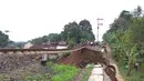 Jalur kereta api tujuan Bogor-Sukabumi longsor terlihat di Kampung Maseng RT02/08, Desa Warung Menteng, Kecamatan Cijeruk, Selasa (5/2). Material longsor menimpa tiga rumah yang ada di bawahnya. (Liputan6.com/Achmad Sudarno)