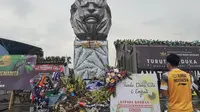Pebulutangkis Pelatnas PBSI, Imanuel Rumbai, melakukan tabur bunga di Stadion Kanjuruhan, Kabupaten Malang, Senin (10/10/2022).  (Bola.com/Yus Mei Sawitri)
