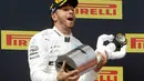 Ekspresi pebalap Mercedes Lewis Hamilton saat memegang trofi juara setelah menjuarai F1 GP Prancis 2019 di Sirkuit Paul Ricard, Minggu (23/6/2019). Hamilton tampil dominan dan menjadi juara F1 GP Prancis 2019. (AP Photo/Claude Paris)