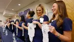 Paige Packard dan Allison Thompson memegang pakaian bayi ketika konferensi pers bersama 16 suster di bagian gawat darurat sebuah rumah sakit di Mesa, Arizona yang sedang hamil pada periode yang relatif bersamaan, 17 Agustus 2018. (AP/Ross D. Franklin)