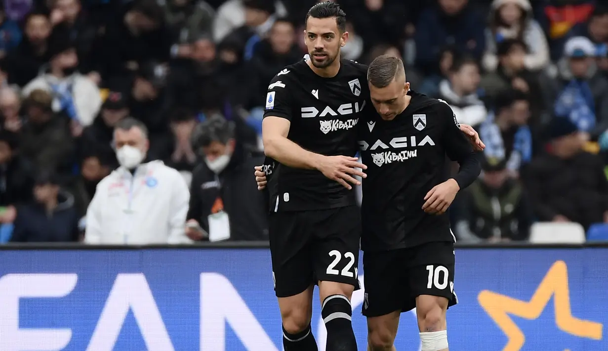 Selebrasi striker Udinese, Gerard Deulofeu (kanan) bersama Pablo Mari setelah mencetak gol ke gawang Napoli pada laga Liga Italia 2021/2022 di Diego-Maradona Stadium, Naples (19/3/2022). Gerard Deulofeu hingga kini masih berseragam Udinese sejak didatangkan pada tengah musim 2020/2021. Catatan gol terbaiknya dibuat pada musim 2021/2022 dengan 13 gol. Gelar top skor diraih Ciro Immobile (Lazio) dengan 27 gol. (AFP/Filippo Monteforte)