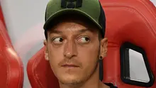 Ekspresi Mesut Ozil saat berada di bangku cadangan saat melihat rekannya bertanding melawan Atletico Madrid di International Champions Cup di Singapura (26/7). Arsenal kalah 3-1 setelah bermain 1-1 di waktu normal. (AFP Photo/Roslan Rahman)