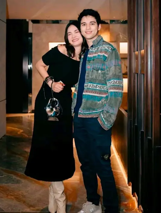 Sedangkan Luna Maya berpose menempel, tampil cantik nan anggun mengenakan dress hitam. Off-the-shoulder dress berwarna hitam, dipadu dengan heels boots cokelat muda, dan ia menenteng tas tangan yang unik. [Foto: Instagram/lunamayaoffc]
