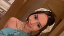 Gaun yang dikenakannya hadir dalam nuansa hijau kebiruan, memberikan kesan segar dan elegan sekaligus. Potongan asimetris dengan aksen lipit-lipit halus pada bagian rok menciptakan efek ombak yang mengalun, seolah menggambarkan keindahan bawah laut.  [@bebytsabina].