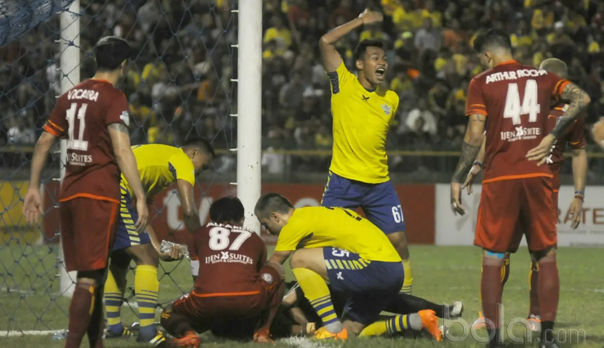 Pemain Persegres Gresik, Aji Saka dibantu rekan-rekannya yang terjatuh usai menghantam tiang gawang sebelah kanan saat melawan Arema FC pada Liga 1 2017 di Gresik, (12/7/2017). (Bola.com/Iwan Setiawan). 