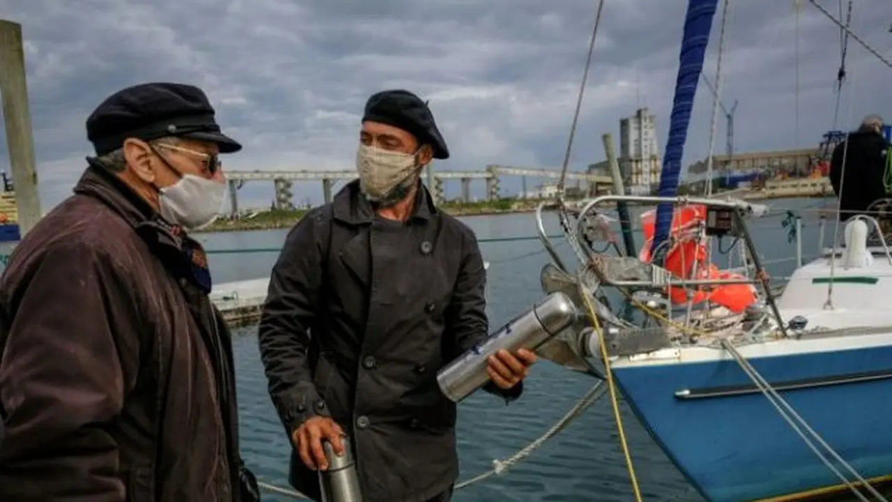 Juan Manuel Ballestero (kanan), disambut oleh ayahnya, Carlos (kiri), saat berhasil berlayar sendirian dari Portugal ke  Mar del Plata, Argentina, demi bertemua kedua orang tuanya (Photo credit: AFP Photo/Diego Izquierdo)