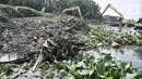 Petugas Suku Dinas Sumber Daya Air Jakarta Utara menggunakan kendaraan alat berat saat membersihkan lumpur Waduk Pluit, Senin (13/6/2022). Pengerukan lumpur rutin ini dilakukan sebagai upaya mengurangi endapan serta tanaman liar dan mencegah banjir di kawasan tersebut. (merdeka.com/Iqbal S Nugroho)