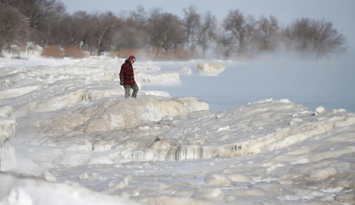 Seorang pria berjalan di Danau Michigan yang membeku saat suhu di bawah 0 derajat Celsius di Milwaukee, Rabu (30/1). Cuaca dingin ekstrem yang terjadi sekali dalam satu generasi sedang melanda beberapa wilayah Amerika Serikat. (AP/Jeffrey Phelps)