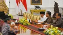 Presiden Joko Widodo (tengah) menyimak penjelasan dari Ketua Umum PP Muhammadiyah Haedar Nashir di Istana Kepresidenan. Senin (13/2). (Liputan6.com/Angga Yuniar)