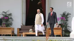 Presiden Joko Widodo dan PM India, Narendra Modi berada di halaman belakang Istana Merdeka, Jakarta, Rabu (30/5). Pertemuan membahas kerja sama pertahanan, di antaranya terkait dengan meriam air buatan Pindad dan Tata Motors. (Liputan6.com/Angga Yuniar)