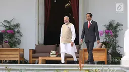 Presiden Joko Widodo dan PM India, Narendra Modi berada di halaman belakang Istana Merdeka, Jakarta, Rabu (30/5). Pertemuan membahas kerja sama pertahanan, di antaranya terkait dengan meriam air buatan Pindad dan Tata Motors. (Liputan6.com/Angga Yuniar)