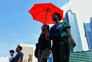 Warga menggunakan payung saat berjalan di tengah cuaca terik di kawasan Bundaran HI, Jakarta, Senin (24/4/2023). Badan Meteorologi Klimatologi dan Geofisika (BMKG) menyampaikan dinamika atmosfer yang tidak biasa menjadi salah satu penyebab Indonesia mengalami suhu panas dalam bebrapa hari terakhir. (Liputan6.com/Angga Yuniar)