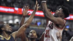 Pemain Chicago Bulls, Jimmy Butler (21) melakukan tembakan saat dihadang para pemain Indiana Pacers pada lanjutan NBA basketball game di United Center, (26/12/2016).  (AP /Paul Beaty)