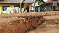 Warga mengamati tanah terbelah di lapangan RT 02 RW 02 Kampung Pedurenan, Kelurahan Cisalak Pasar, Cimanggis, Depok, Jawa Barat, Senin (22/10). Tanah tersebut terbelah sepanjang 20 meter dengan kedalaman 1,5 meter. (Liputan6.com/Immanuel Antonius)