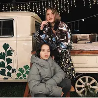Bunga Citra Lestari merayakan malam tahun baru cukup unik di vintage campervan picnic bersama buah hati. Ia pun mengenakan pakaian tabrak motif dengan jaket sebagai luaran dan long dress bermotif didominasi warna hitam. Sepatu boots cokelat pun dipilih BCL sebagai alas kakinya. Dok. bclsinclair