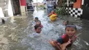 Hujan yang mengguyur Jakarta sejak Minggu (8/2) lalu, membuat Waduk Ria Rio meluap. Para bocah ini asyik bermain saat bajir melanda kawasan rumah mereka di Pendongkelan, Jakarta, Selasa (10/2/2015). (Liputan6.com/Herman Zakharia)