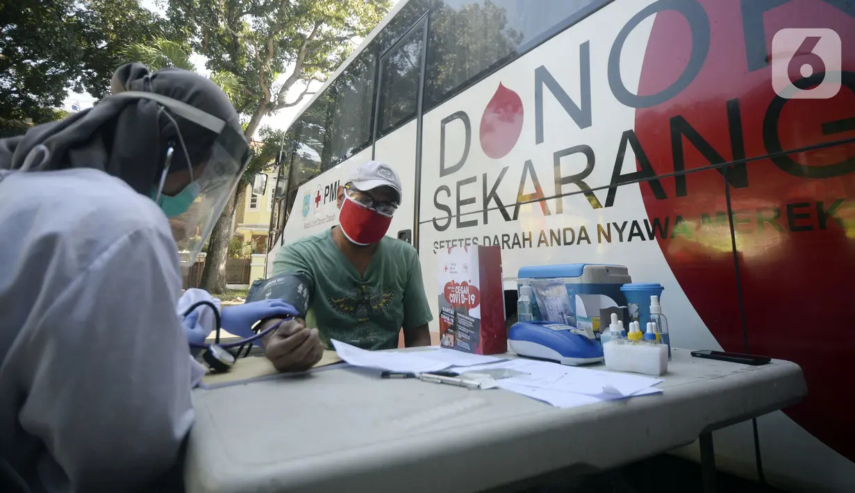 Petugas Palang Merah Indonesia (PMI) memeriksa kondisi pendonor dekat mobil donor darah keliling, Tangerang Selatan, Banten, Jumat (17/7/2020). PMI mengintensifkan pengoperasian mobil donor darah keliling untuk memenuhi persediaan stok darah saat pandemi COVID-19. (merdeka.com/Dwi Narwoko)