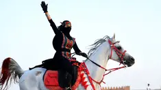 Perempuan Arab melambaikan tangan saat menunggangi kuda dalam Festival Souk Okaz 2019 di Kota Taif, Arab Saudi, Rabu (7/8/2019). Tahun ini merupakan pertama kalinya perempuan diizinkan untuk berpartisipasi dalam Festival Souq Okaz 2019. (AMER HILABI/AFP)
