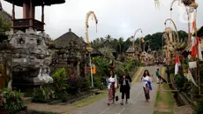 Wisatawan berjalan menyusuri kawasan Desa Penglipuran di Kabupaten Bangli, Bali, Rabu (16/8/2023). (Liputan6.com/Helmi Fithriansyah)