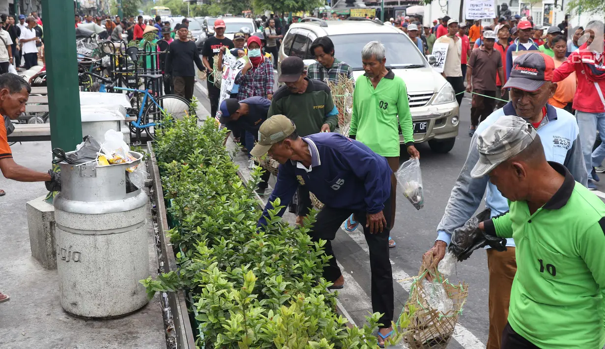 Kelompok pengemudi becak motor bersama aktivis melakukan aksi berjalan kaki sambil memunguti sampah menuju titik Nol kilometer Yogyakarta, Senin (22/4). Aksi memperingati Hari Bumi ini mengajak masyakarat untuk mengurangi sampah dan penggunaan plastik. (Liputan6.com/Helmi Fithriansyah)