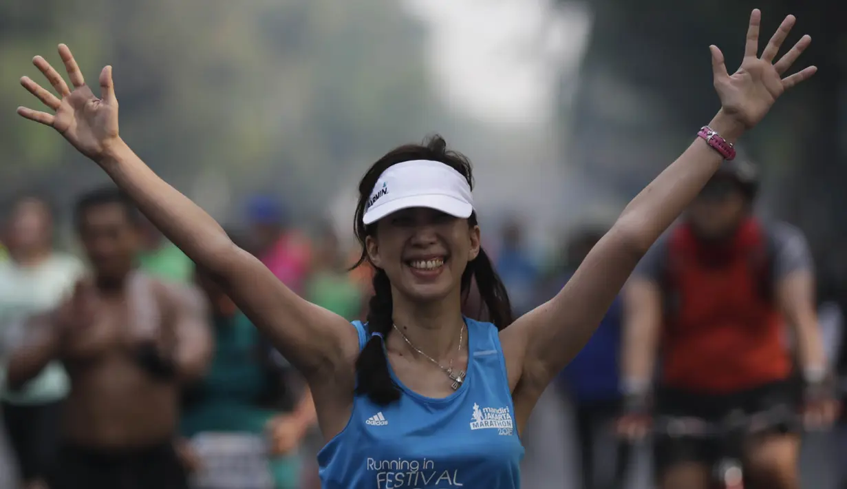 Peserta Mandiri Jakarta Marathon 2015 tampak ceria saat berlari menuju finish di halaman Monumen Nasional, Minggu (25/10/2015). (Bola.com/Vitalis Yogi Trisna)