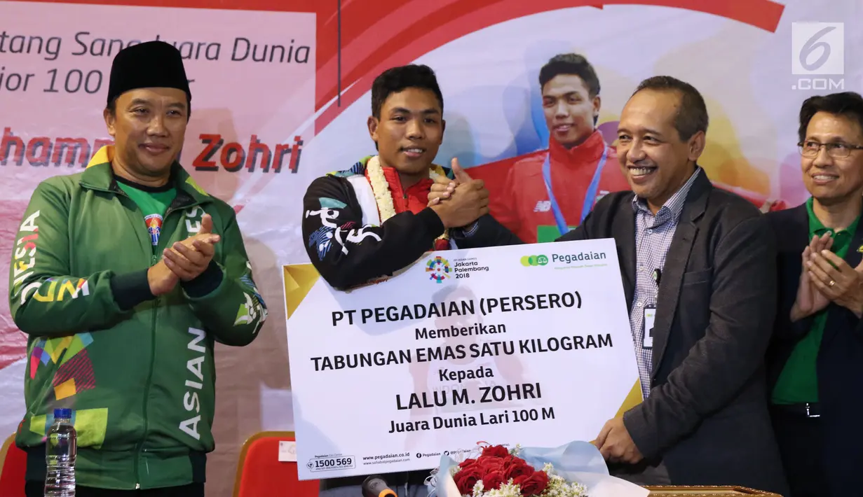Pelari muda Indonesia, Lalu Muhammad Zohri (kedua kiri) menerima bonus dari pihak pegadaian di Terminal 3 Bandara Soetta, Tangerang, Selasa (17/7). Lalu M Zohri meraih emas lari 100m putra di Kejuaraan Dunia U-20 IAAF. (Liputan6.com/Helmi Fithriansyah)