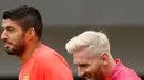 Penyerang Barcelona, Lionel Messi (kanan) dan Luis Suarez saat latihan bersama rekan setim di St Georges Park National Football Centre, Inggris, Senin (25/7). Rambut pirang Messi sempat membuat heboh netizen. (REUTERS/ Darren Staples)