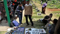 Salah satu dagangan yang dijajakan seorang pedagang di makam Olga Syahputra di TPU Malaka, Jakarta, Selasa (31/3/2015). Empat hari pascakepergian komedian Olga, antusiasme masyarakat berkunjung ke makam masih tinggi. (Liputan6.com/Panji Diksana)