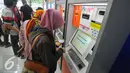 Calon penumpang membeli tiket di mesin penjual tiket kereta api otomatis di Stasiun Senen, Jakarta, Selasa (20/12). Jelang libur Natal dan tahun baru tiket Kereta Api sudah habis untuk keberangkatan Jateng dan Jatim. (Liputan6.com/Angga Yuniar)