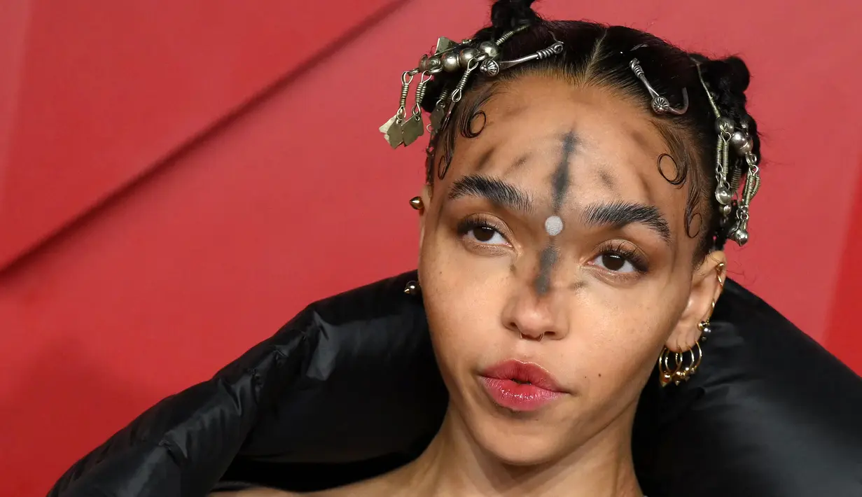 FKA Twigs berpose untuk fotografer setibanya di British Fashion Awards di London, Senin, 5 Desember 2022. Penyanyi sekaligus penulis lagu asal Inggris itu tampil mengenakan tampilan riasan unik di acara tersebut. (AFP/DANIEL LEAL)