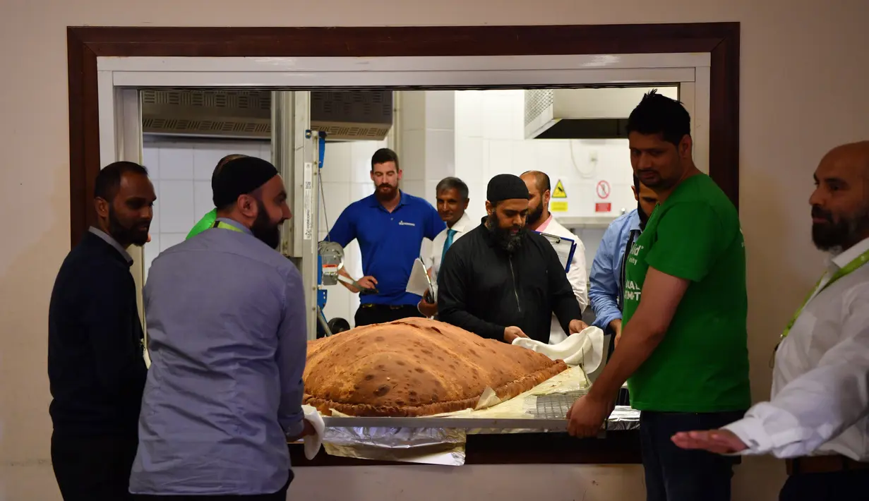 Koki dan relawan Muslim Aid membuat samosa raksasa seberat 153 kilogram di Masjid London Timur, Inggris, Selasa (22/8). Samosa raksasa itu kemudian dipotong hingga berjumlah ratusan dan didistribusikan ke tunawisma di Salvation Army. (BEN STANSALL/AFP)