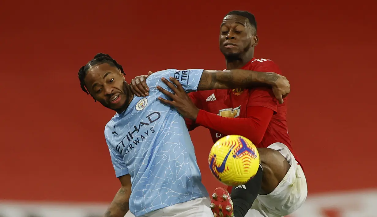 Striker Manchester City, Raheem Sterling (kiri), berebut bola dengan bek Manchester United, Aaron Wan-Bissaka dalam laga lanjutan Liga Inggris 2020/21 pekan ke-12 di Old Trafford Stadium, Sabtu (12/12/2020). Manchester City bermain imbang 0-0 dengan Manchester United. (Pool via AP/Phil Noble)