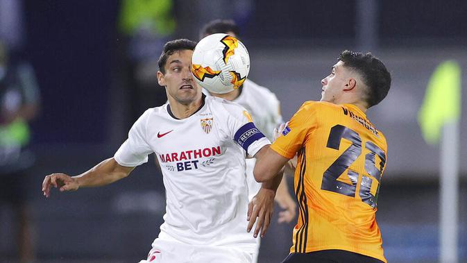 Pemain Sevilla, Jesus Navas, berebut bola dengan pemain Wolverhampton Wanderers, Ruben Vinagre, pada perempat final Liga Europa, Selasa (11/8/2020). Sevilla menang dengan skor 1-0. (Friedemann Vogel, Pool Photo via AP)