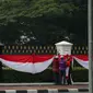 Sejumlah pekerja sibuk memasang kain berwarna merah putih dipagar depan Istana Merdeka Jakarta, Senin (13/4/2015). Jelang Konferensi Asia Afrika (KAA) ke-60 di Bandung pada 24 April mendatang, Istana Merdeka mulai dipercantik. (Liputan6.com/Faizal Fanani)