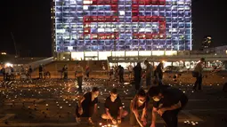 Warga menyalakan lilin pada peringatan 25 tahun pembunuhan Perdana Menteri Israel Yitzhak Rabin, di Rabin Square, Tel Aviv, Kamis (29/10/2020). Sebanyak 25 ribu lilin dinyalakan oleh warga Israel untuk memperingati pembunuhan  Yitzhak Rabin. (AP Photo/Oded Balilty)