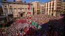Anggota ‘Castellers’ Barcelona membentuk menara manusia yang disebut ‘Castell’ di alun-alun Sant Jaume, Barcelona, Spanyol, Minggu (24/9). Kelompok akar rumput memimpin gerakan kemerdekaan Catalonia dengan membangun Castell. (AP Photo/Emilio Morenatti)