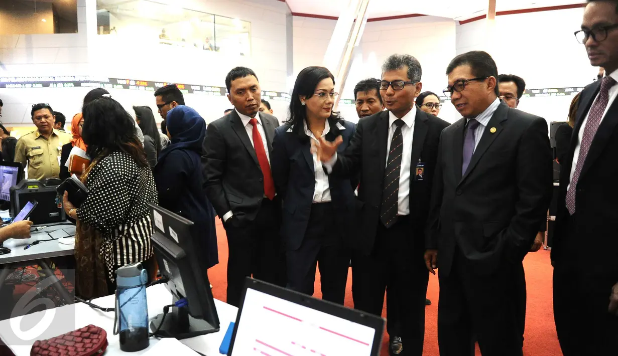 Ketua Dewan Komisioner OJK Muliaman D Hadad , Wakil Direktur Utama Sunarso bersama Direktur Utama KSEI Friderica Widya meninjau stand proses integrasi e-KTP di Gedung Bursa Efek Indonesia (BEI), Jakarta, Selasa (22/11). (Liputan6.com/Angga Yuniar)