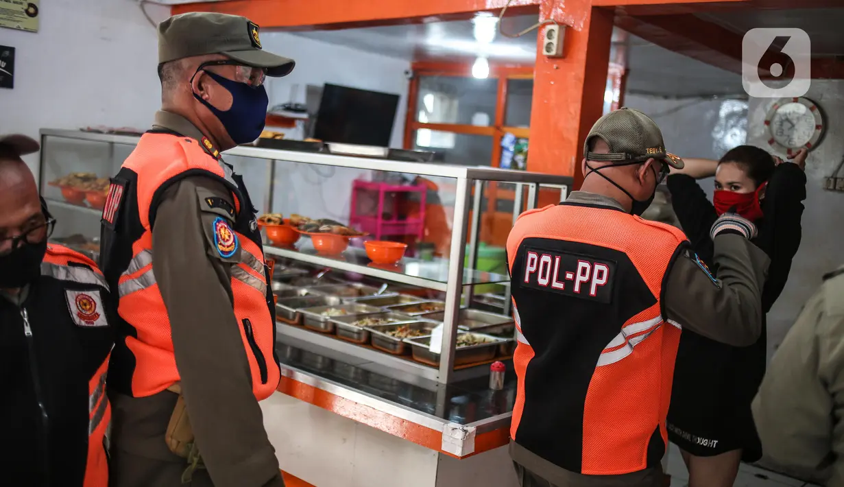 Petugas Satpol PP menertibkan warung makan yang melanggar aturan pembatasan sosial berskala besar (PSBB) di kebon kacang, Jakarta, Senin (1/6/2020). Pelanggaran berupa menerima pelanggan yang makan di warung ditertibkan oleh petugas untuk mencegah penyebaran COVID-19. (Liputan6.com/Faizal Fanani)