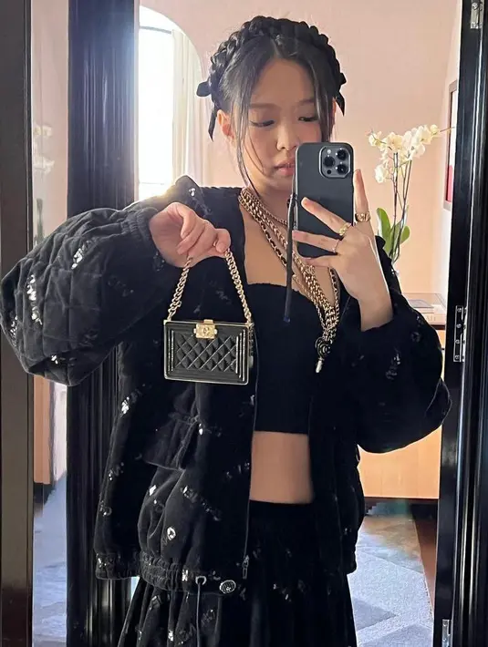 Penampilannya semakin terlihat stunning dengan jaket puff oversized hitam, micro bag Chanel dan sepatu platform heels open toe warna hitam. (Instagram/jennierubyjane).