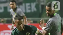 Kapten tim Persikabo 1973, Manahati Lestusen mengecoh pemain Persebaya Surabaya pada lanjutan pekan pertama BRI Liga 1 Indonesia 2022-2023 di Stadion Pakansari, Kabupaten Bogor, Senin (25/7/2022). Persikabo 1973 unggul atas Persebaya Surabaya lewat gol dari titik penalti yang dicetak Gustavo Tocantins. (Liputan6.com/Helmi Fithriansyah)