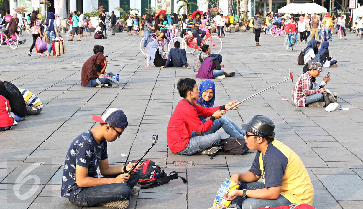 Sejumlah remaja berfoto bersama saat berwisata di Kota Tua, Jakarta, Minggu (8/5). Keunikan bangunan tua di kawasan tersebut menjadi daya tarik tersendiri bagi warga untuk melakukan foto bersama atau selfie. (Liputan6.com/Immanuel Antonius)