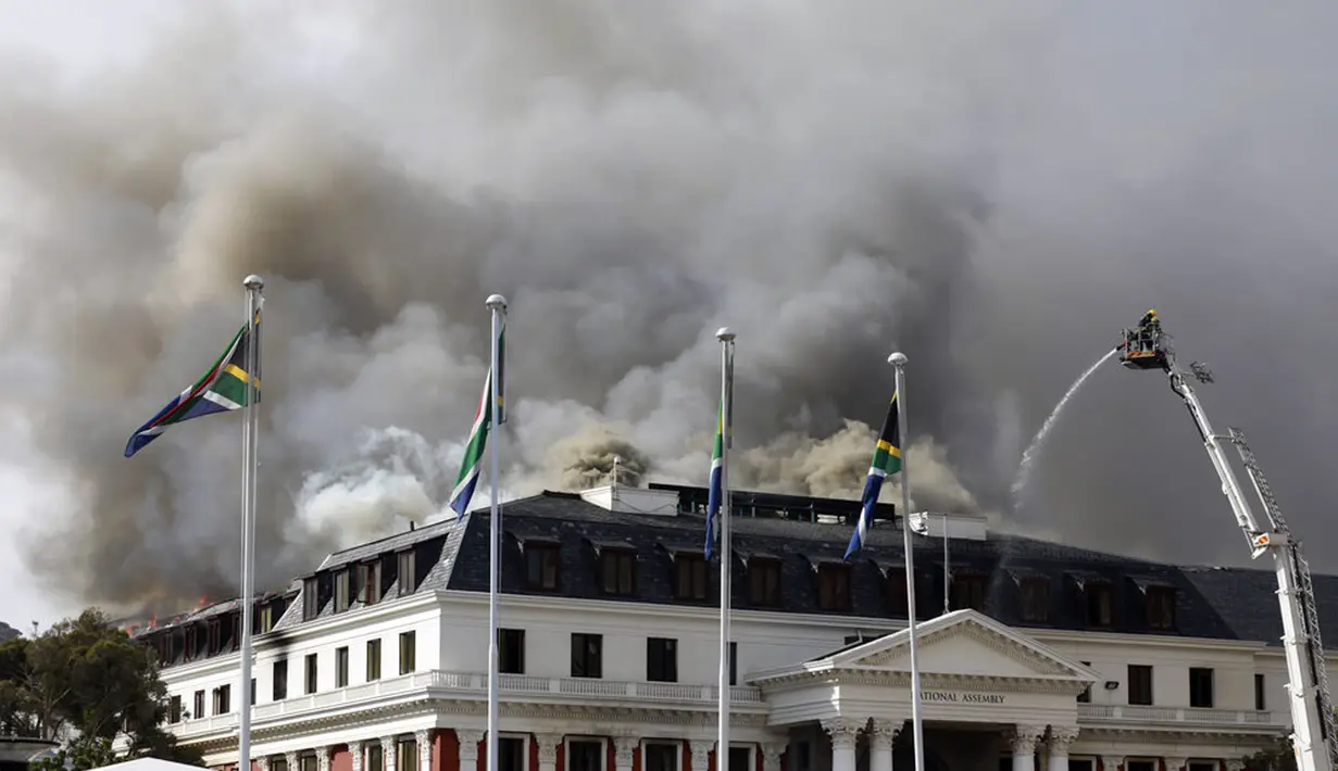 Asap mengepul dari Gedung Parlemen di Cape Town, Afrika Selatan, 3 Januari 2022. ​Setelah sempat berhasil dipadamkan, api kembali mengamuk dan membakar Gedung Parlemen Afrika Selatan. (AP Photo/Nardus Engelbrecht)